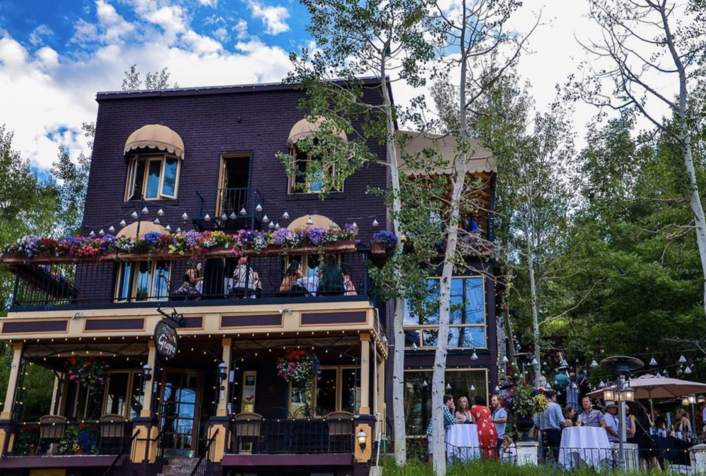 A three story, purple, creole style building with an outdoor patio housing the Grappa restaurant, one of the best restaurants in Park City, Utah.