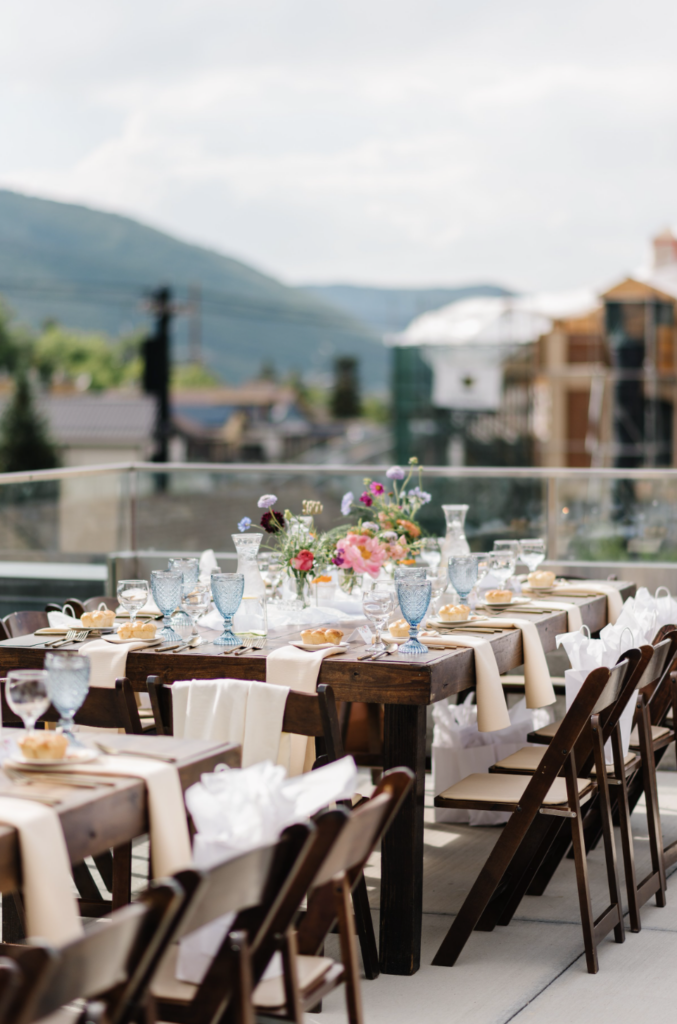 A feminine, floral laden table-scape on the rooftop patio at Kimball Terrance, one of the best restaurants in Park City, Utah.